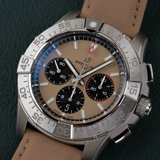 Breitling Avenger AB0147101A1X1 - close-up frontaal onder een hoek met zandkleurige wijzerplaat en zwarte subdials