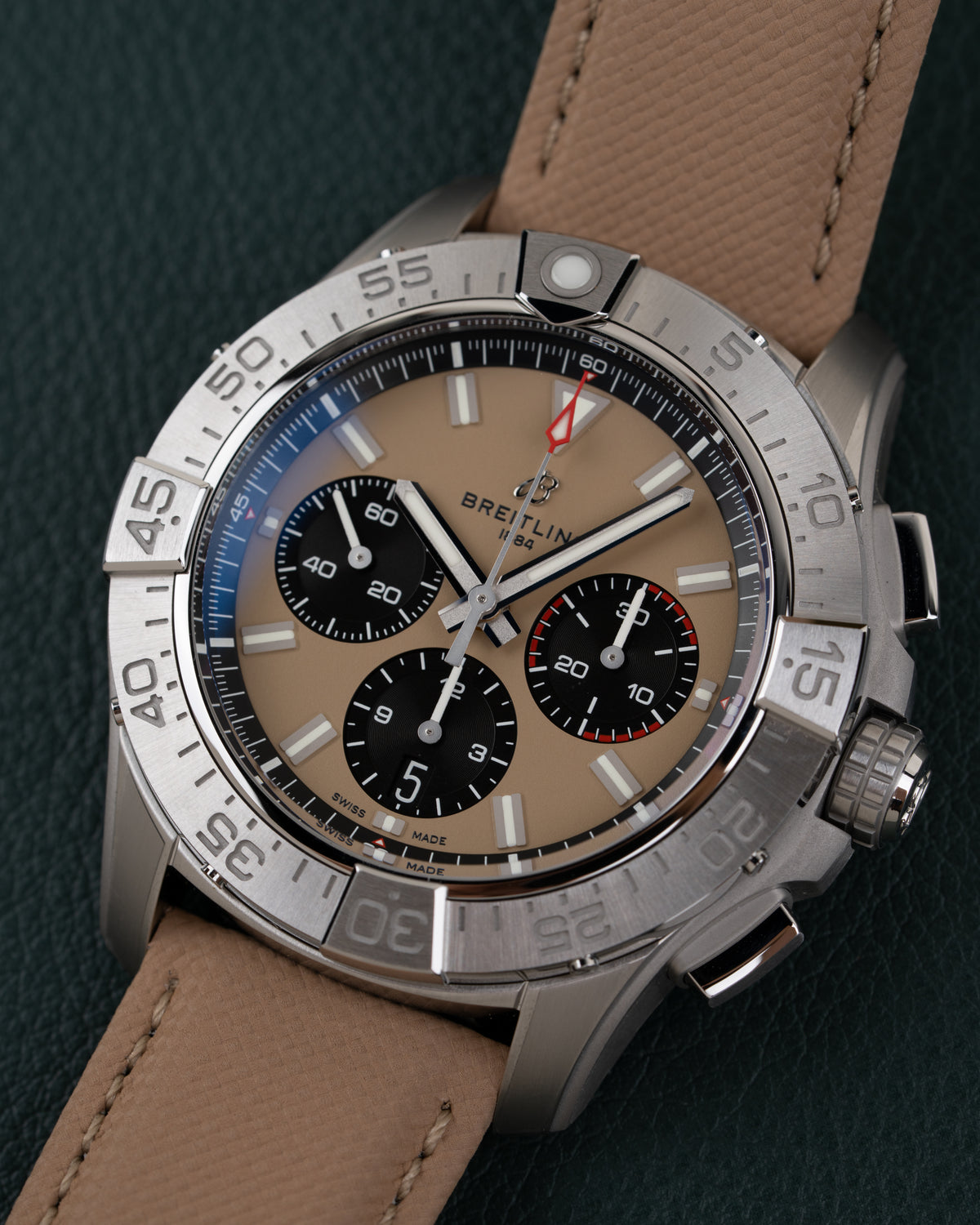 Breitling Avenger AB0147101A1X1 - close-up frontaal onder een hoek met zandkleurige wijzerplaat en zwarte subdials