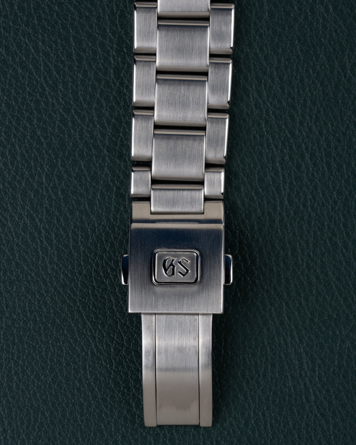 Grand Seiko Heritage Collection SBGV221 - Close-up van de vouwsluiting met GS-logo op de stalen schakelband