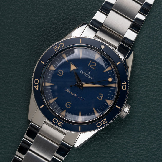 OMEGA Seamaster 300 Co-Axial 234.30.41.21.03.001 - horloge onder een hoek met blauwe bezel en schakelband
