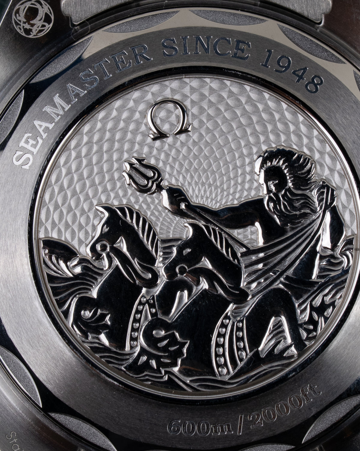 Omega Seamaster Planet Ocean 600M 215.30.40.20.03.002 - close-up van de kastachterkant met graveerwerk van Poseidon en Seamaster Since 1948 tekst