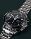 Omega Speedmaster Day-Date 3520.50 - close-up onder een lichte hoek met kroon en drukknoppen scherp in beeld