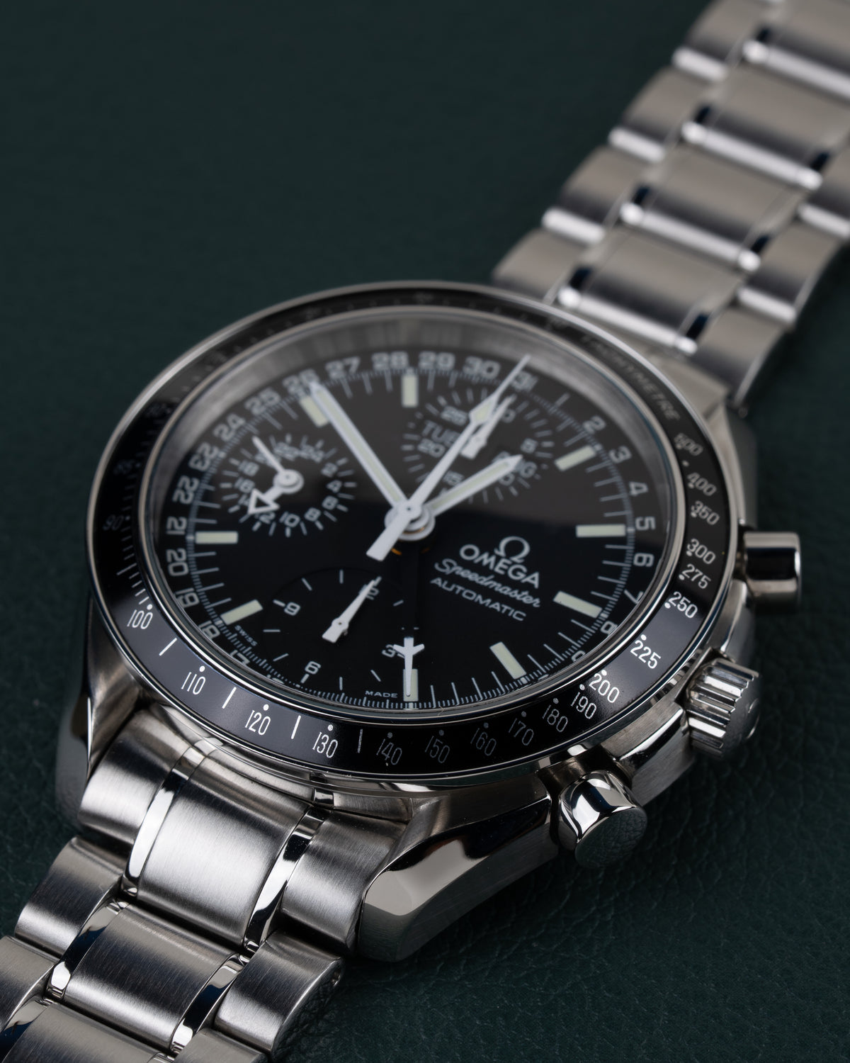 Omega Speedmaster Day-Date 3520.50 - close-up onder een lichte hoek met kroon en drukknoppen scherp in beeld