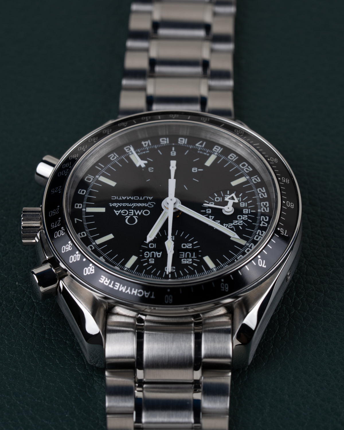 Omega Speedmaster Day-Date 3520.50 - frontaal aanzicht ondersteboven met kroon en drukknoppen zichtbaar aan de linkerzijde