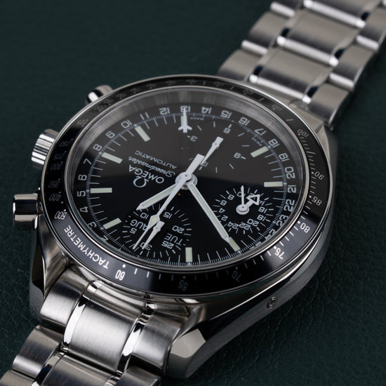 Omega Speedmaster Day-Date 3520.50 - close-up onder een hoek ondersteboven met de kroon en drukknoppen scherp in beeld