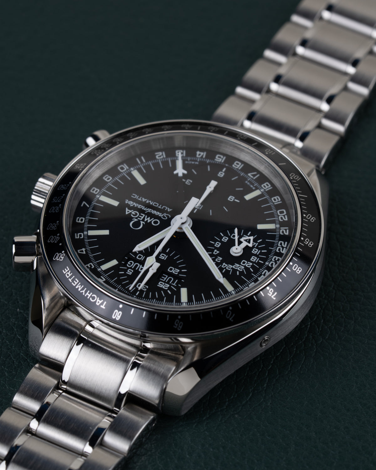 Omega Speedmaster Day-Date 3520.50 - close-up onder een hoek ondersteboven met de kroon en drukknoppen scherp in beeld