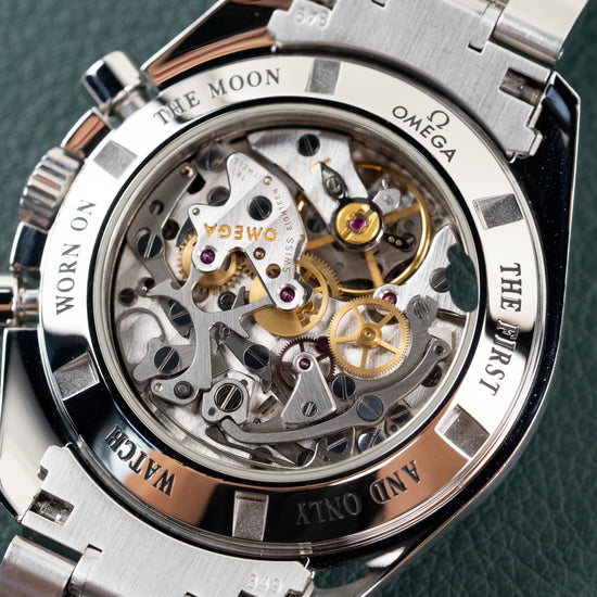 Omega Speedmaster Professional Moonwatch 3573.50 - doorzichtige saffierglazen caseback onder een hoek met zicht op het handopwindende uurwerk en gravure The First Watch Worn On The Moon