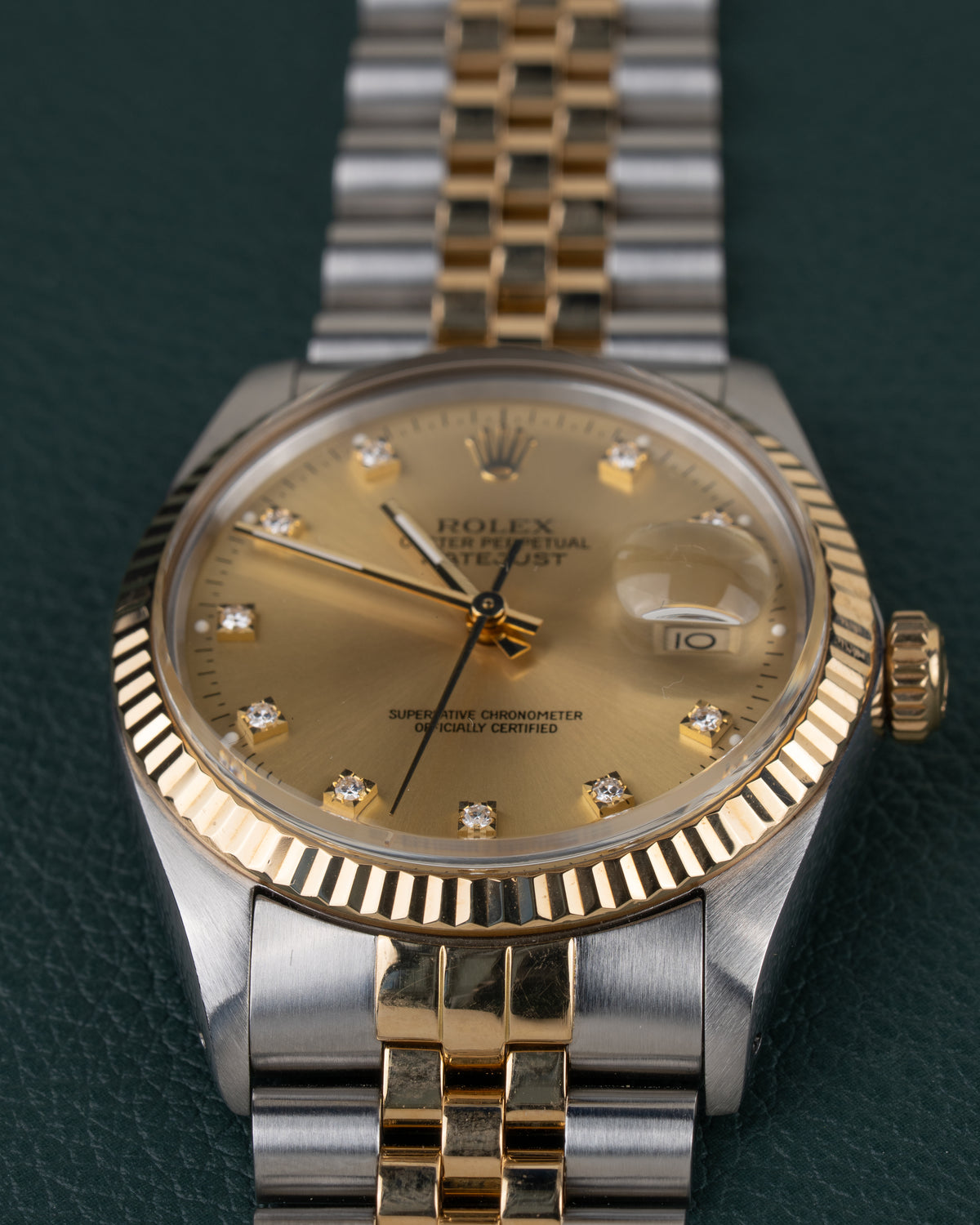 Rolex Datejust 16013 Champagne Diamanten Dial - close-up van de wijzerplaat met gefacetteerde gouden bezel en Cyclops-datumlens
