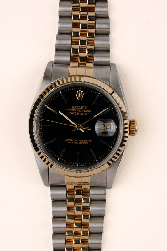 Rolex Datejust 16233 - vooraanzicht van de zwarte wijzerplaat, geribbelde gouden bezel en armband