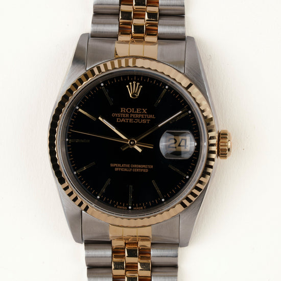 Rolex Datejust 16233 - vooraanzicht van de zwarte wijzerplaat, geribbelde gouden bezel en armband