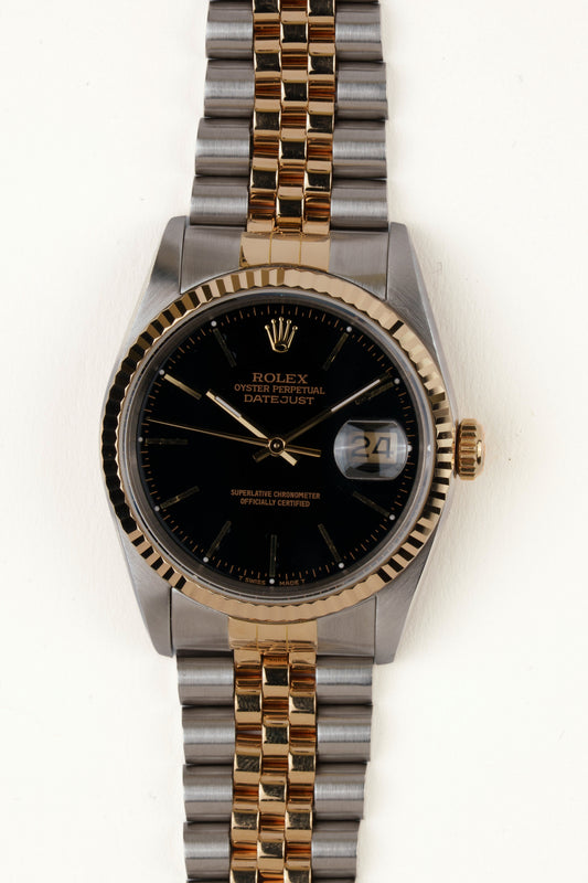 Rolex Datejust 16233 - vooraanzicht van de zwarte wijzerplaat, geribbelde gouden bezel en armband