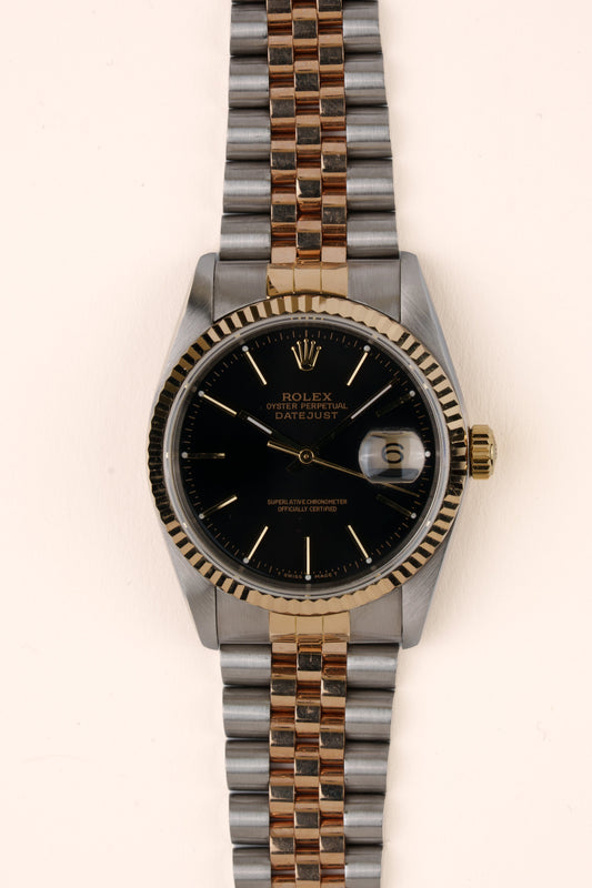 Rolex Datejust 16233 - vooraanzicht van de zwarte wijzerplaat, geribbelde gouden bezel en armband