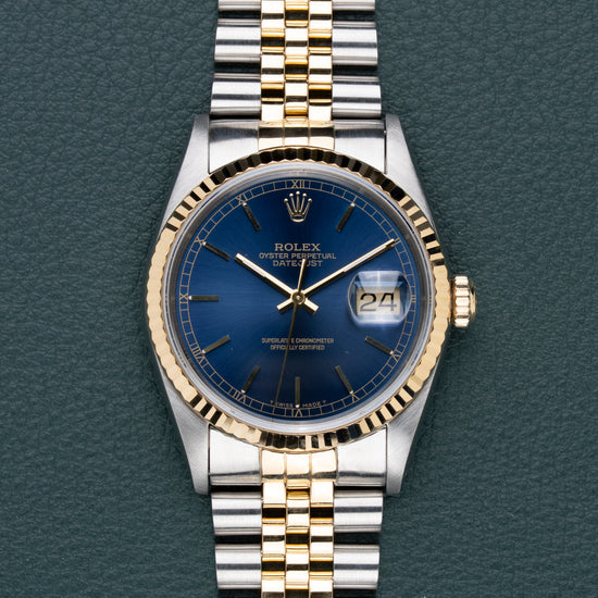 Rolex Datejust 16233 Blue Dial - frontaal aanzicht met blauwe sunburst wijzerplaat, gouden fluted bezel en Jubilee band