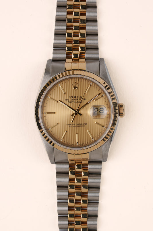 Rolex Datejust 16233 - vooraanzicht van de champagne wijzerplaat, geribbelde gouden bezel en armband