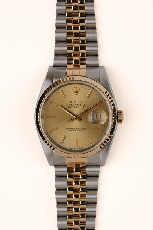 Rolex Datejust 16233 - vooraanzicht van de champagne wijzerplaat, geribbelde gouden bezel en Jubilee-armband