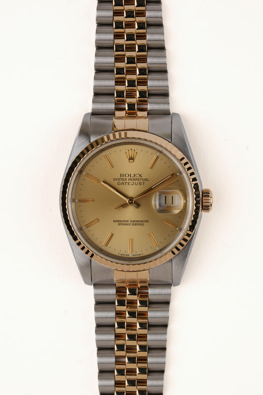 Rolex Datejust 16233 - vooraanzicht van de champagne wijzerplaat, geribbelde gouden bezel en Jubilee-armband
