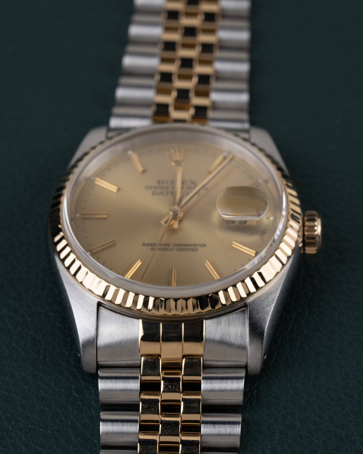 Rolex Datejust 16233 - Close-up frontaal onder een andere hoek met de gefacetteerde gouden bezel scherp in beeld