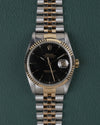 Rolex Datejust 16233 Black Dial 1991 - Volledig horloge recht van boven met zwarte wijzerplaat, gefacetteerde bicolor bezel en jubilee-band