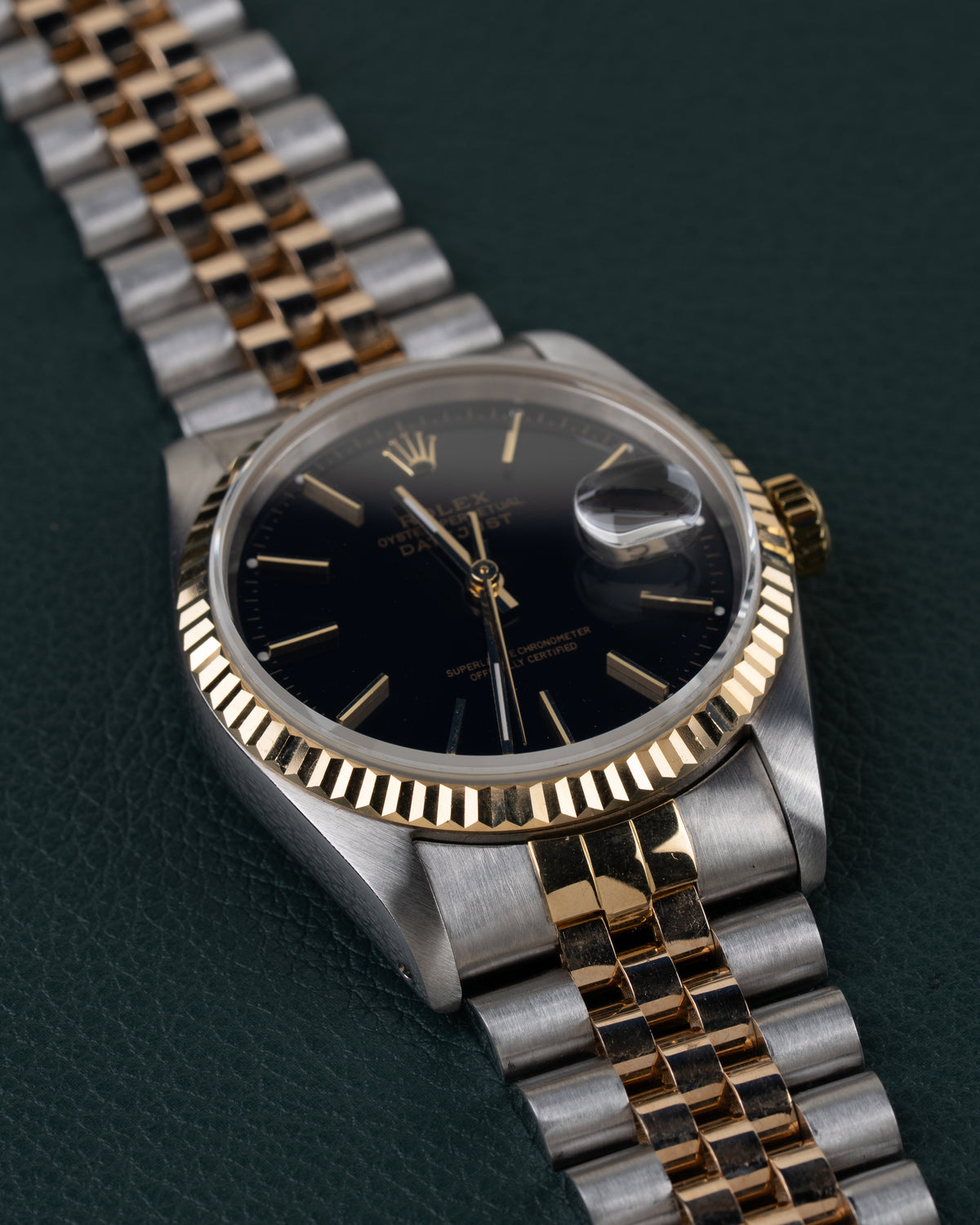 Rolex Datejust 16233 Black Dial 1991 - Frontaal aanzicht onder een hoek met de kroon rechts en de jubilee-band schuin naar boven links