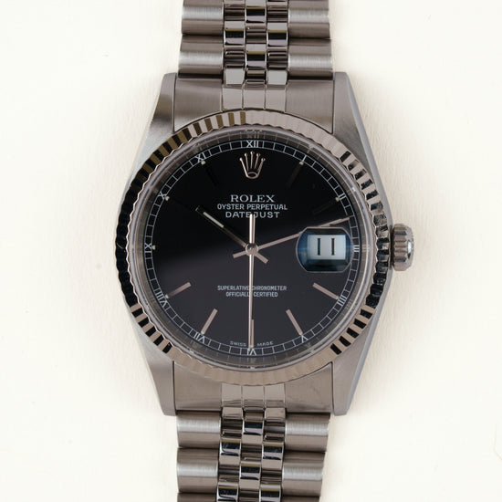 Rolex Datejust 16234 - vooraanzicht van de zwarte wijzerplaat, geribbelde witgouden bezel en armband