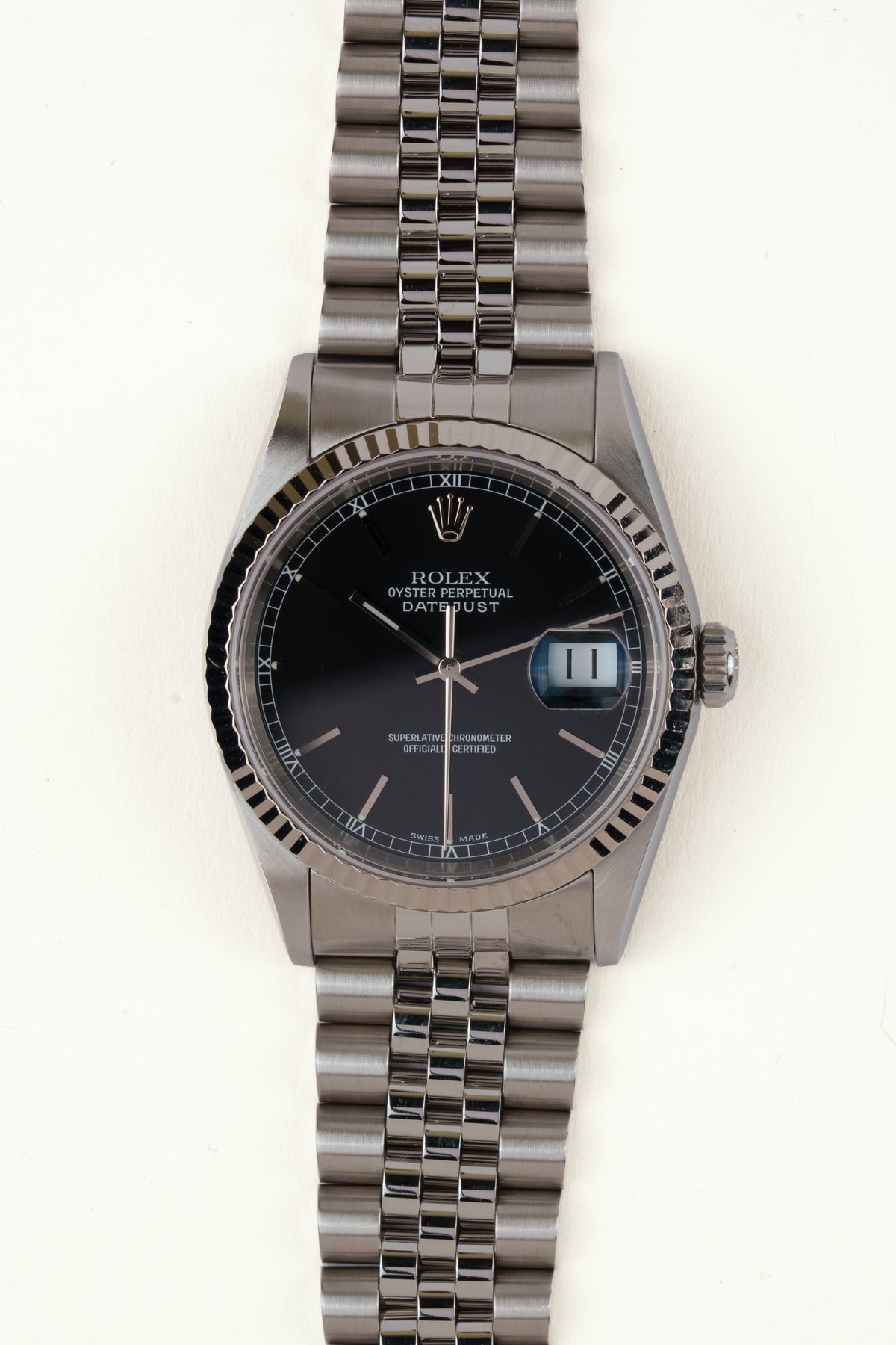 Rolex Datejust 16234 - vooraanzicht van de zwarte wijzerplaat, geribbelde witgouden bezel en armband