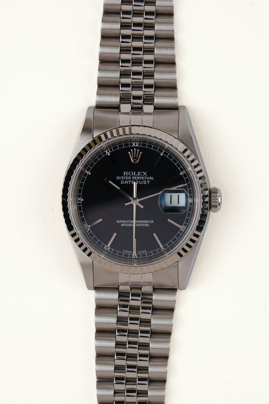 Rolex Datejust 16234 - vooraanzicht van de zwarte wijzerplaat, geribbelde witgouden bezel en armband