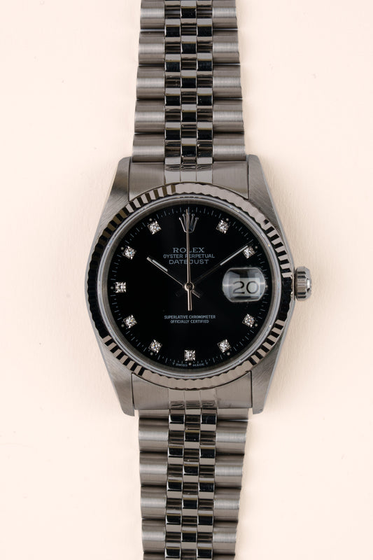 Rolex Datejust 16234 - vooraanzicht van de zwarte wijzerplaat met diamanten indexen, geribbelde witgouden bezel en armband