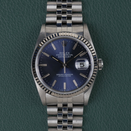 Rolex Datejust 16234 Blue Dial 1991 - Volledig horloge recht van boven met blauwe wijzerplaat, gefacetteerde stalen bezel en jubilee-band