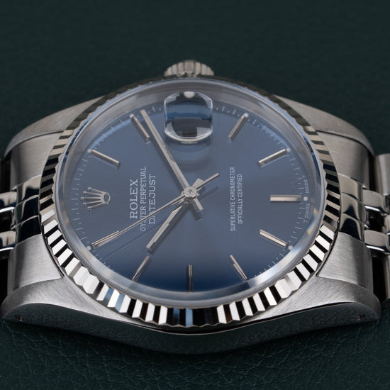 Rolex Datejust 16234 Blue Dial - close-up van wijzerplaat en fluted bezel met kroon verborgen aan andere zijde
