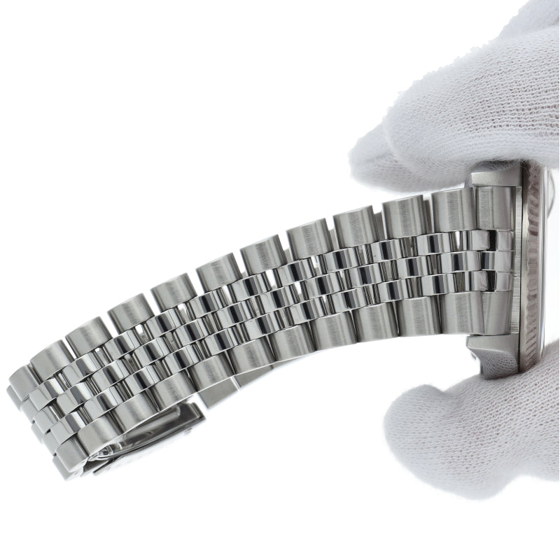 Rolex Datejust 16234 Silver Dial - close-up van de Jubilee band vastgehouden met inspectiehandschoenen