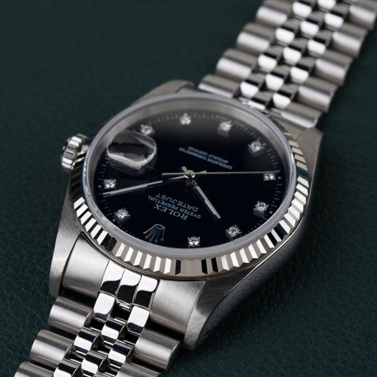 Rolex Datejust 16234 Black Diamond Dial 1994 - Ondersteboven aanzicht onder een hoek met de kroon links en de jubilee-band schuin naar boven rechts