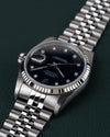 Rolex Datejust 16234 Black Diamond Dial 1994 - Ondersteboven aanzicht onder een hoek met de kroon links en de jubilee-band schuin naar boven rechts