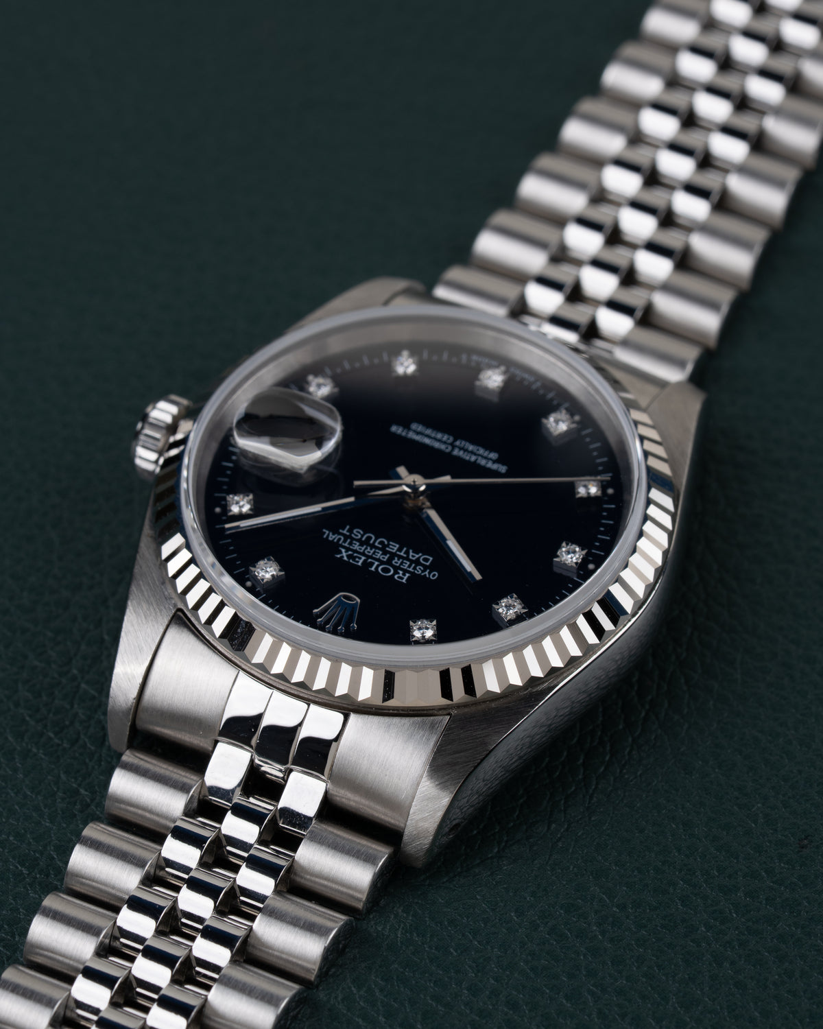 Rolex Datejust 16234 Black Diamond Dial 1994 - Ondersteboven aanzicht onder een hoek met de kroon links en de jubilee-band schuin naar boven rechts