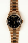 Rolex Day-Date 18038 - vooraanzicht van de zwarte wijzerplaat met diamanten indexen, geribbelde gouden bezel en President-armband